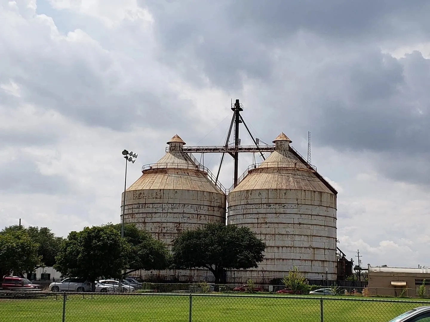 A large grain silo sitting in the middle of a field.