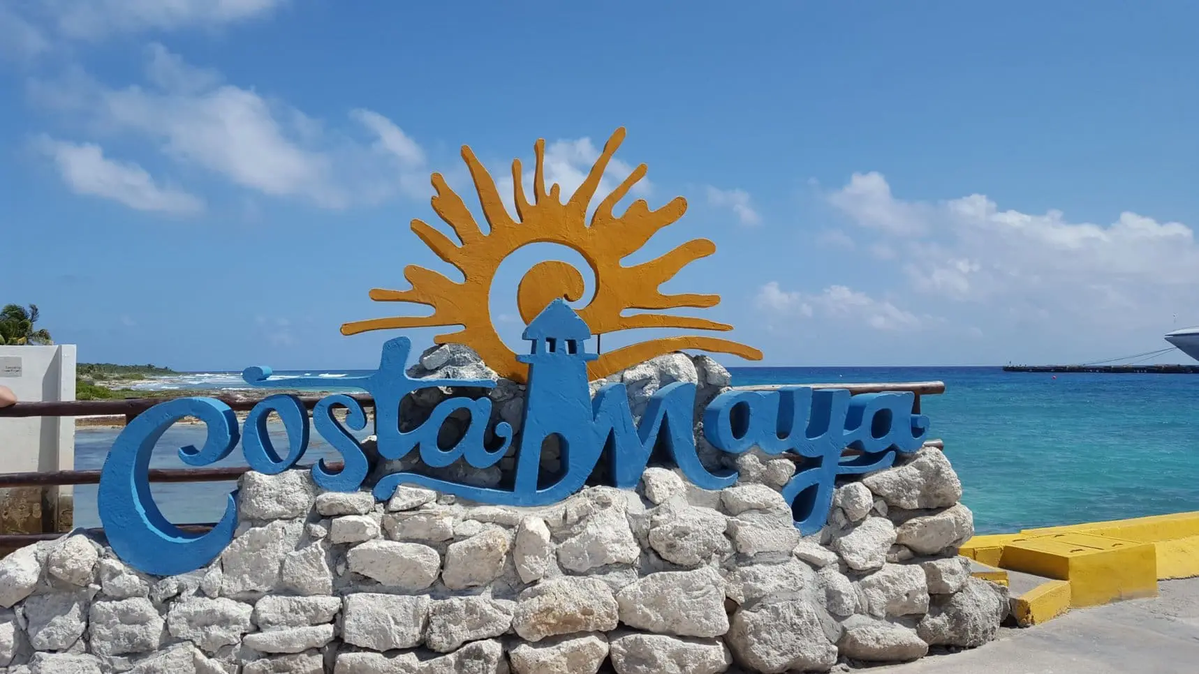 A sign that says costa maya with the sun in the background.