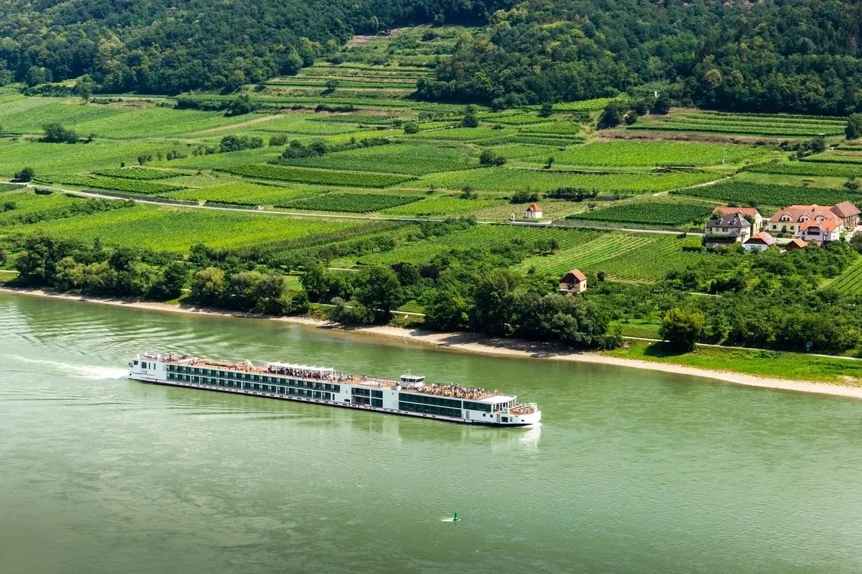 A large boat is in the water near some hills