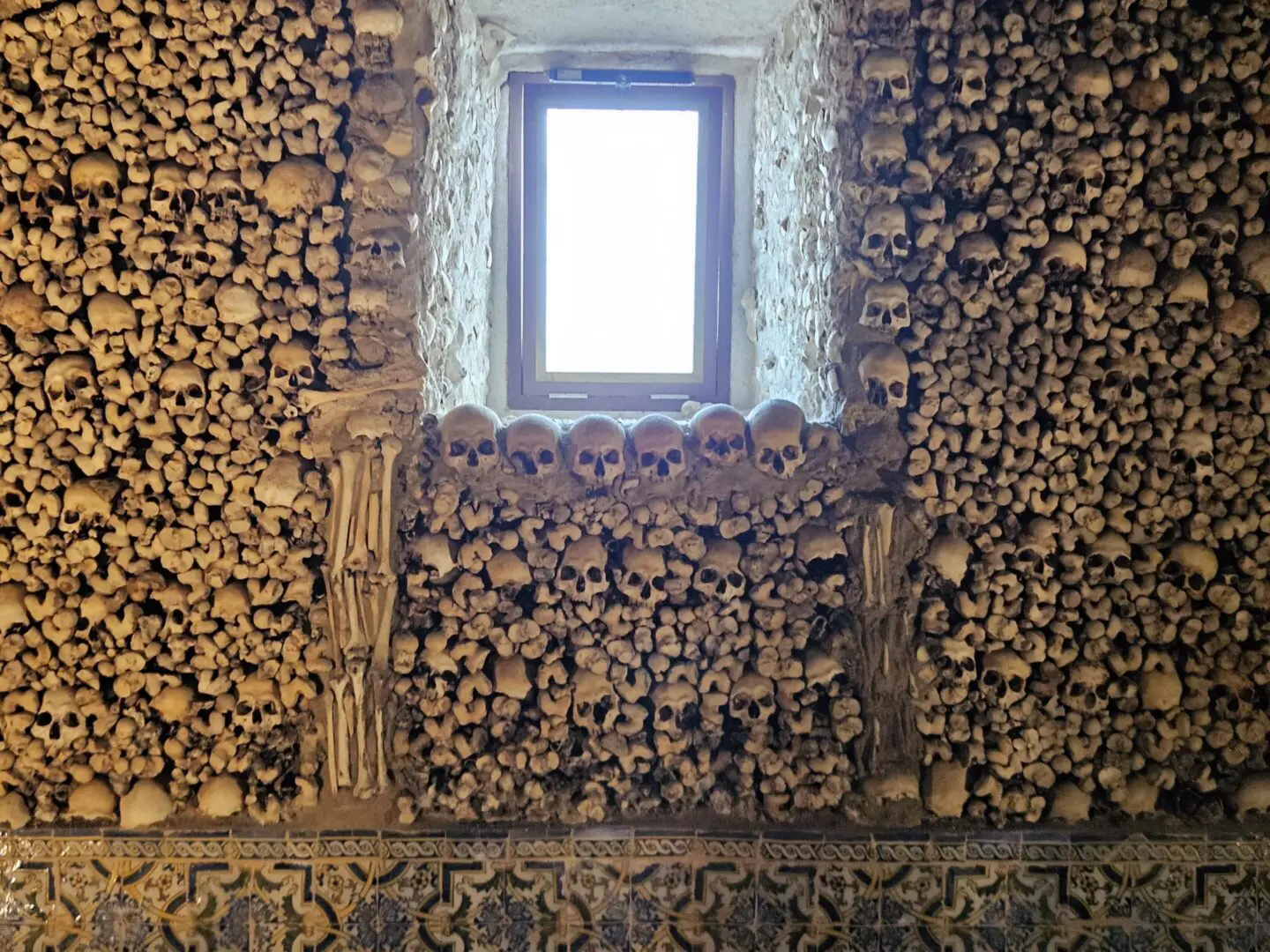 Wall decorated with human skulls and bones.