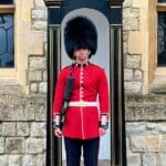 Guardsman in red uniform at Buckingham Palace.