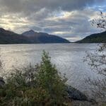 Serene loch and mountain landscape.