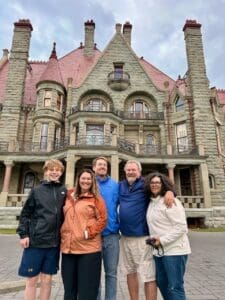 Group posing in front of historic mansion.